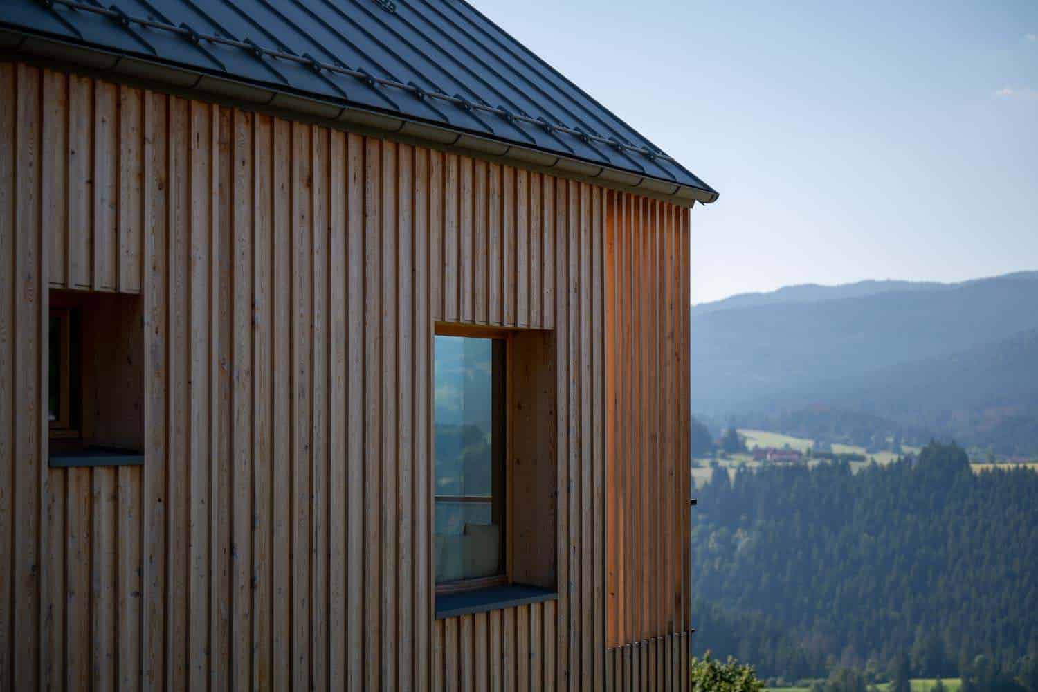 Dettaglio interno con travi in legno a vista e lampada a sospensione