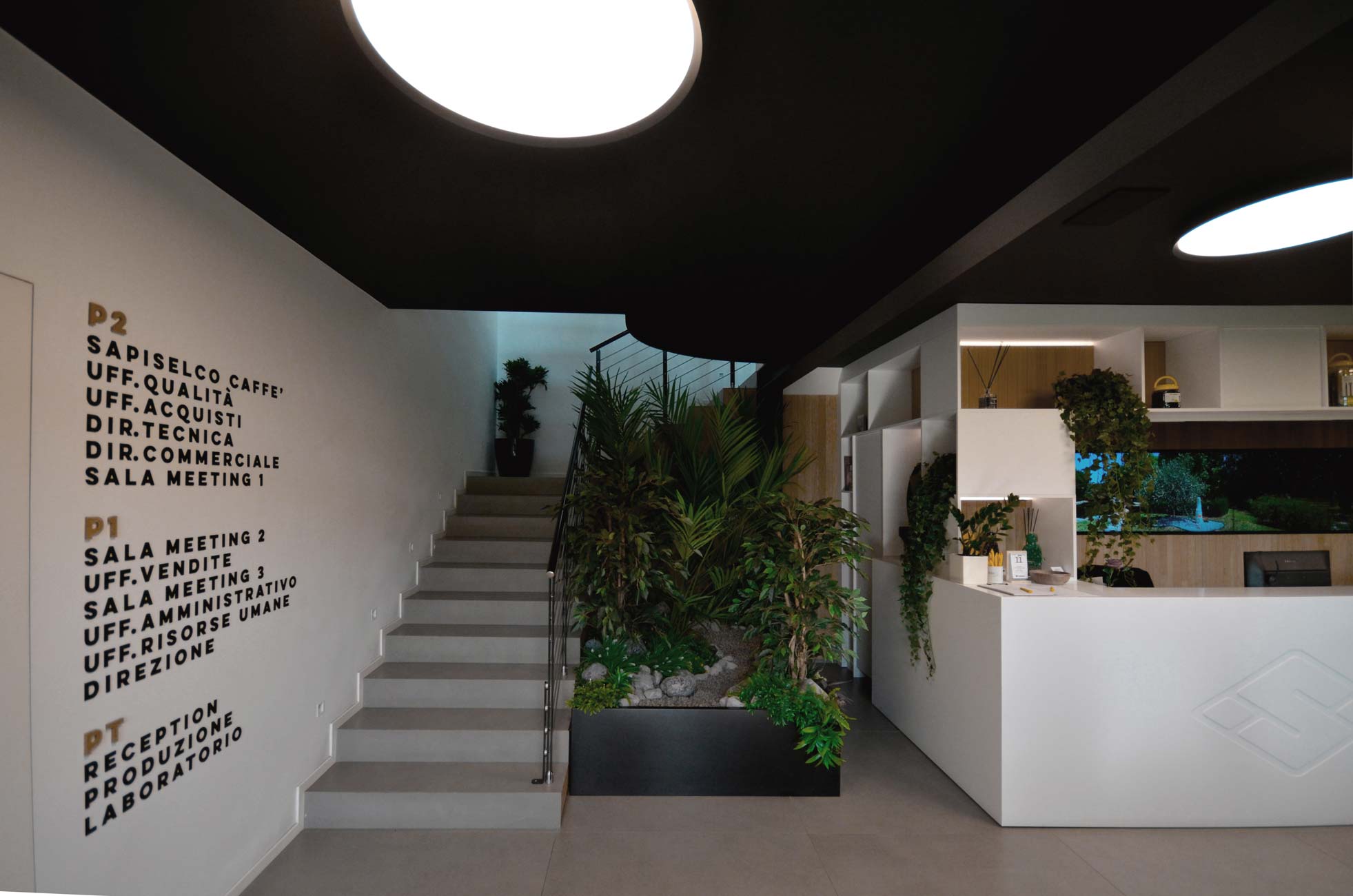 Uffici Sapiselco con pareti vetrate e scrivanie bianche